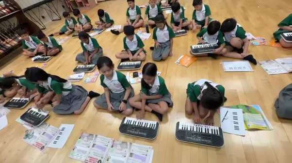 Students practising keyboard skills during a music lesson in the classroom.